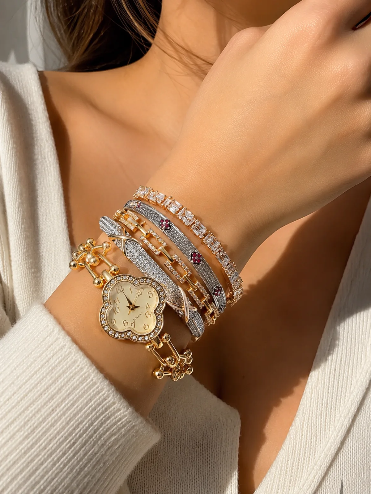 Composição de pulseiras e relógio dourado da Love